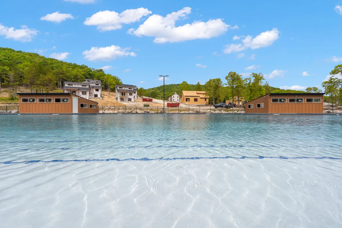 A tranquil lakeside scene featuring waterfront buildings surrounded by lush greenery and clear, inviting water. The area is ideal for boating, fishing, and relaxing by the shore, with natural landscapes that invite exploration and outdoor adventure.