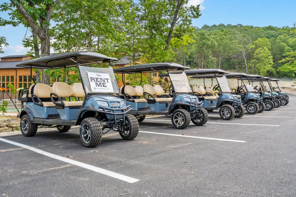 A playful exterior scene featuring golf carts marked 'RENT ME' and surrounded by trees, suggesting opportunities for exploration and unique experiences during the stay.
